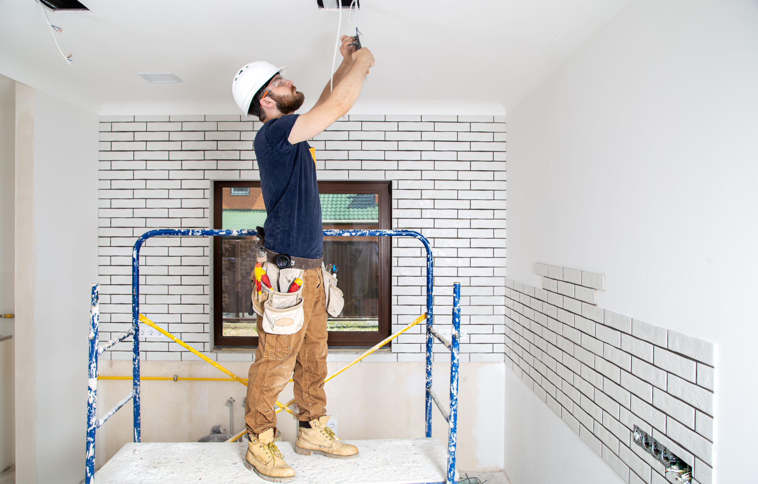 Professional in overalls with tools on the background of the repair site. Home renovation concept.